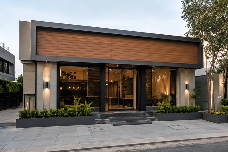 Small commercial building facade with premium WPC exterior cladding, modern glass entrance, clean landscaping, and contemporary architectural design.